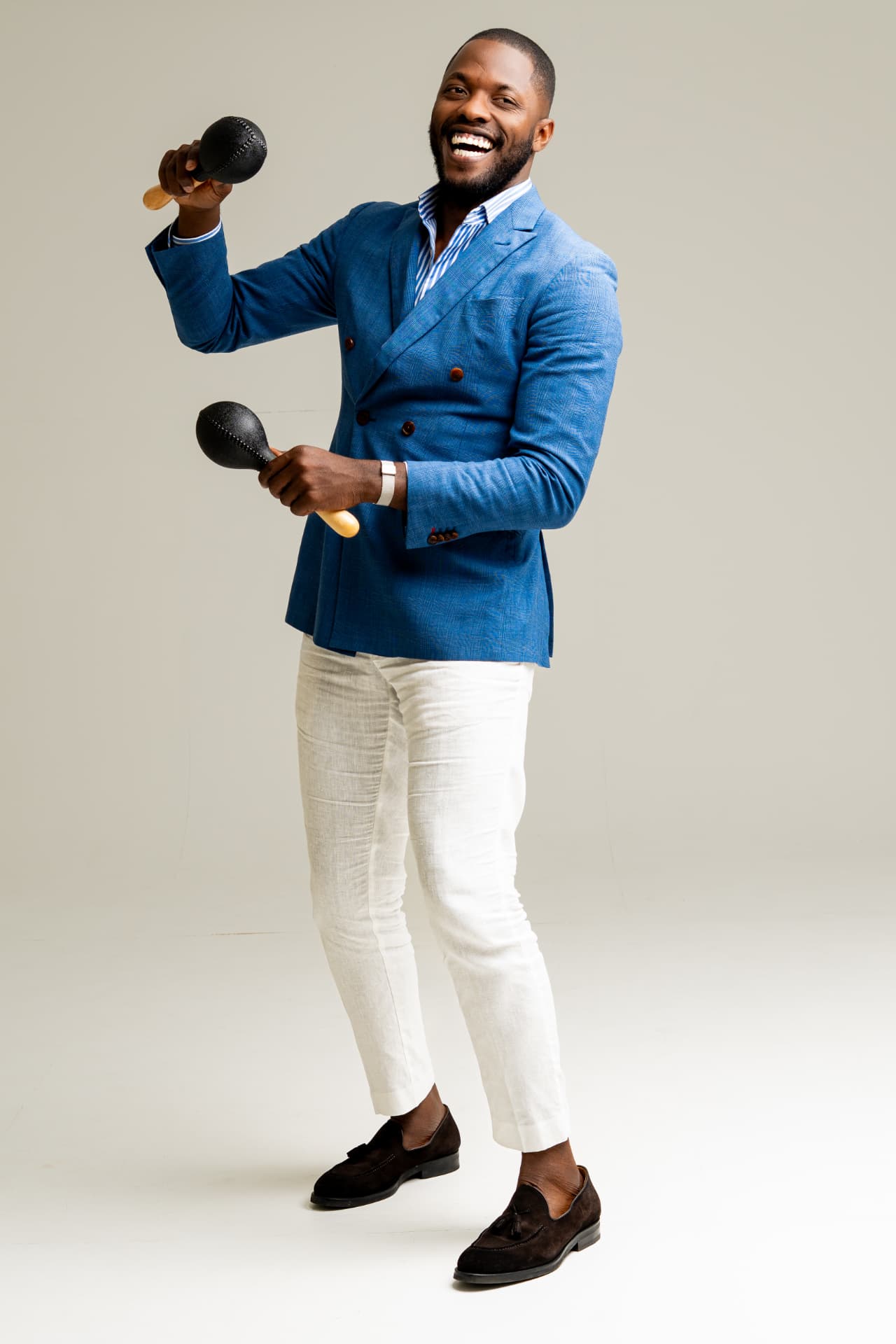 Salsa instructor in a bright blue blazer holding maracas